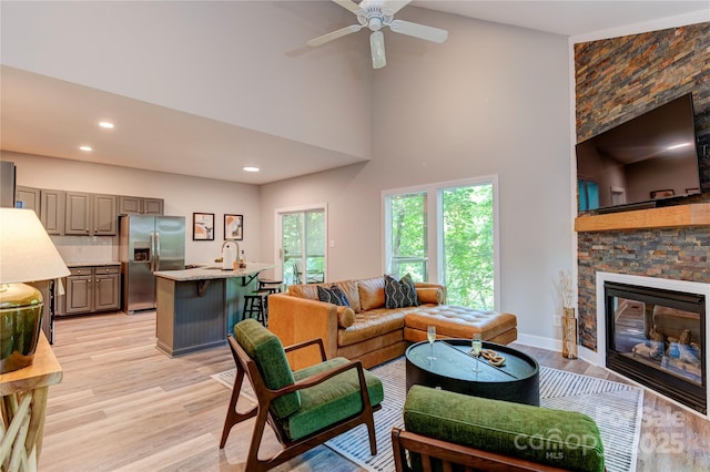 145 Inn At Crestwood Dr, Boone, NC 28607 - living area featuring light wood-type flooring, ceiling fan, a stone fireplace, recessed lighting, and a high ceiling