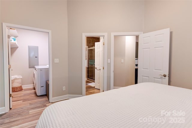 145 Inn At Crestwood Dr, Boone, NC 28607 - bedroom featuring washer and dryer, electric panel, light wood-style flooring, a towering ceiling, and baseboards