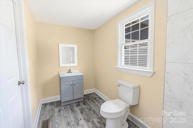 921 W 1st St, Lowell, NC 28098 - bathroom with toilet, wood finished floors, vanity, and baseboards