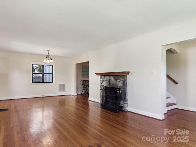 27 Alabama Ave, Weaverville, NC 28787 - unfurnished living room featuring wood finished floors, arched walkways, stairs, a stone fireplace, and baseboards