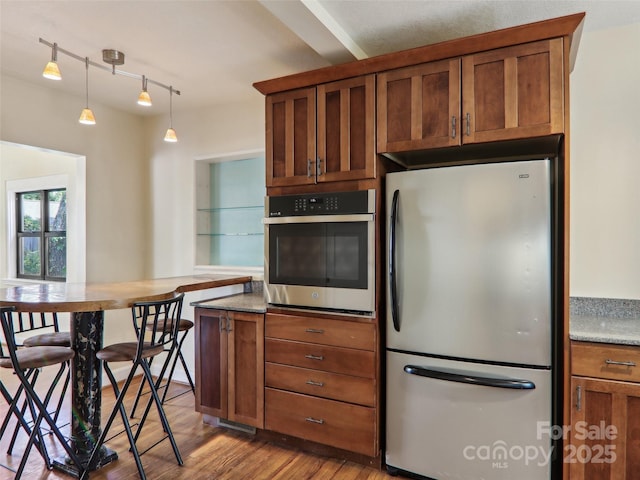 27 Alabama Ave, Weaverville, NC 28787 - kitchen with stainless steel appliances, brown cabinetry, wood finished floors, and hanging light fixtures