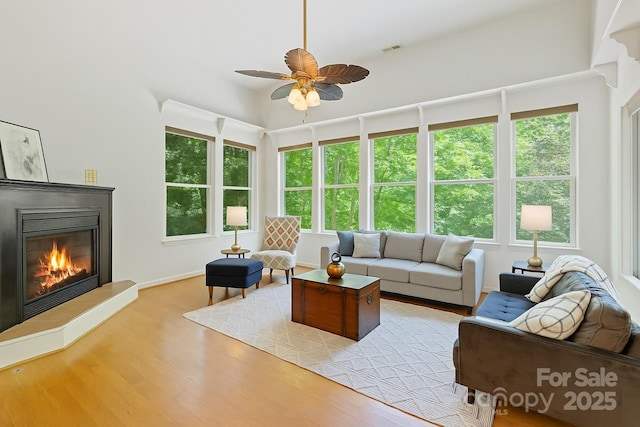 190 Jonathan Creek Dr, Etowah, NC 28729 - living room featuring a glass covered fireplace, a ceiling fan, and light wood-style floors
