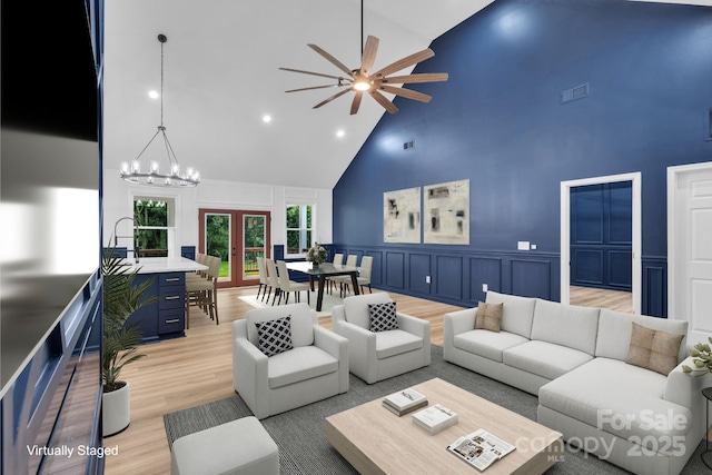 1246 Bob Falls Rd, Shelby, NC 28150 - living area with high vaulted ceiling, a decorative wall, ceiling fan, light wood finished floors, and a wainscoted wall