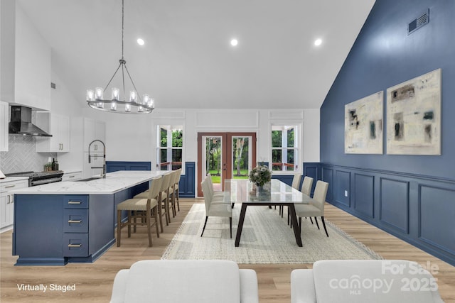 1246 Bob Falls Rd, Shelby, NC 28150 - dining room with high vaulted ceiling, a decorative wall, light wood finished floors, a chandelier, and french doors