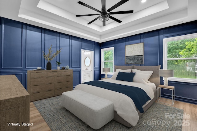 1246 Bob Falls Rd, Shelby, NC 28150 - bedroom with a tray ceiling, a decorative wall, light wood finished floors, a ceiling fan, and connected bathroom