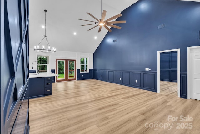 1246 Bob Falls Rd, Shelby, NC 28150 - unfurnished living room featuring high vaulted ceiling, a decorative wall, ceiling fan, wainscoting, and a chandelier