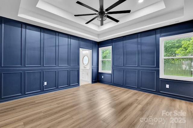 1246 Bob Falls Rd, Shelby, NC 28150 - unfurnished room with a raised ceiling, a decorative wall, a ceiling fan, and light wood finished floors
