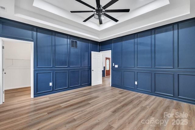 1246 Bob Falls Rd, Shelby, NC 28150 - unfurnished room with a tray ceiling, a decorative wall, a ceiling fan, and light wood-style floors