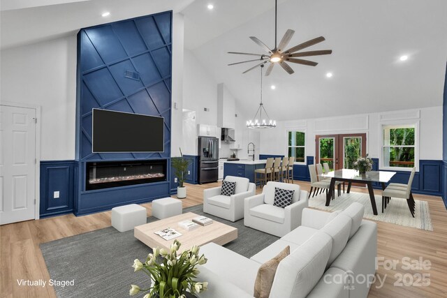 1246 Bob Falls Rd, Shelby, NC 28150 - living area featuring high vaulted ceiling, a decorative wall, a ceiling fan, light wood-style floors, and wainscoting