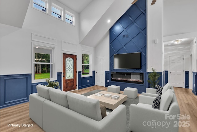 1246 Bob Falls Rd, Shelby, NC 28150 - living room featuring a towering ceiling, a decorative wall, light wood finished floors, plenty of natural light, and a wainscoted wall