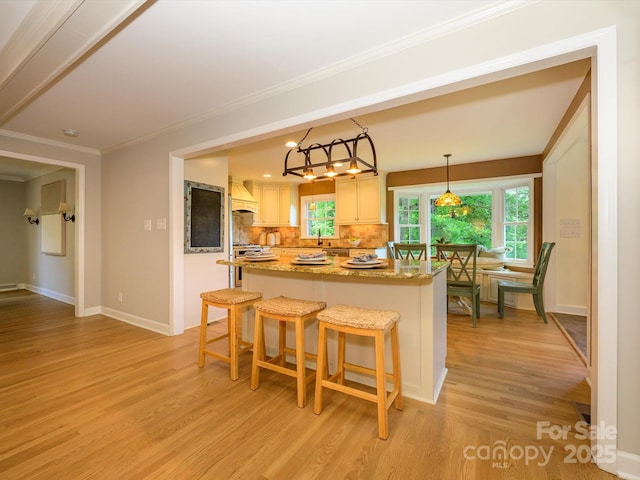 7356 Terrace Dr, Charlotte, NC 28211 - kitchen with premium range hood, a center island, light wood-style floors, crown molding, and tasteful backsplash