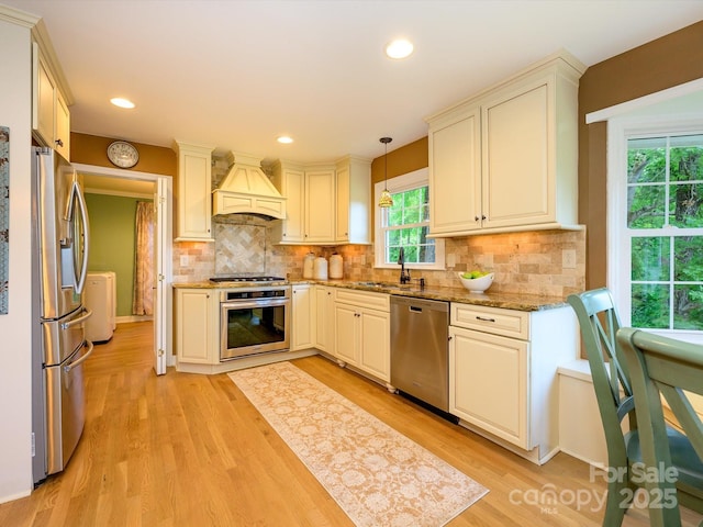 7356 Terrace Dr, Charlotte, NC 28211 - kitchen with stainless steel appliances, premium range hood, a sink, light stone counters, and light wood-type flooring