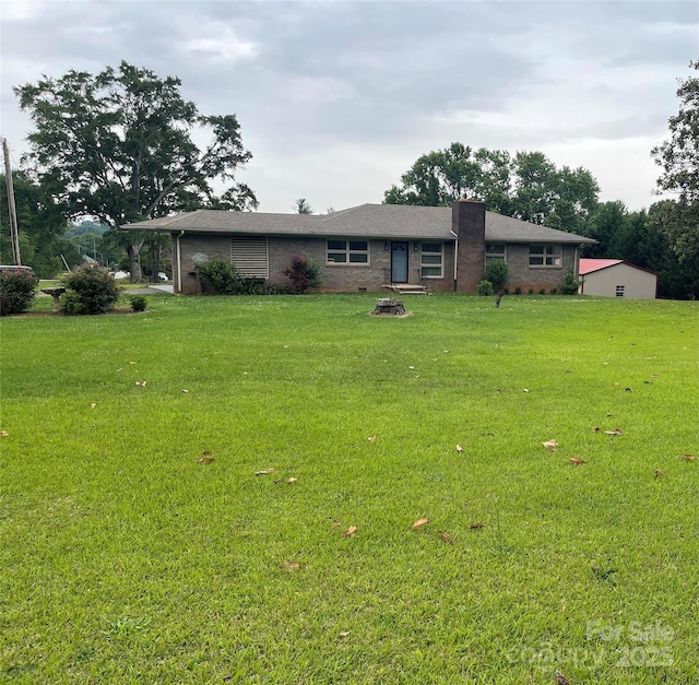 114 Aqua Dr, Forest City, NC 28043 - view of front of house featuring brick siding, a front lawn, and a fire pit