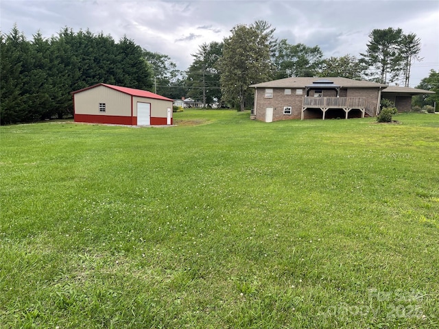 114 Aqua Dr, Forest City, NC 28043 - view of green lawn featuring a wooden deck, a detached garage, and an outbuilding