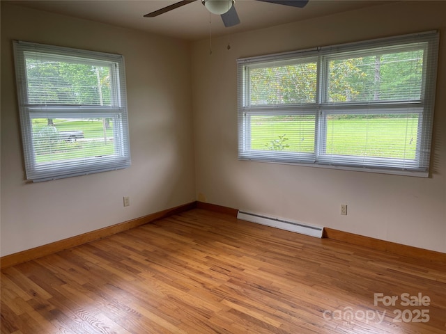114 Aqua Dr, Forest City, NC 28043 - empty room with a baseboard heating unit, a ceiling fan, healthy amount of natural light, and light wood-type flooring