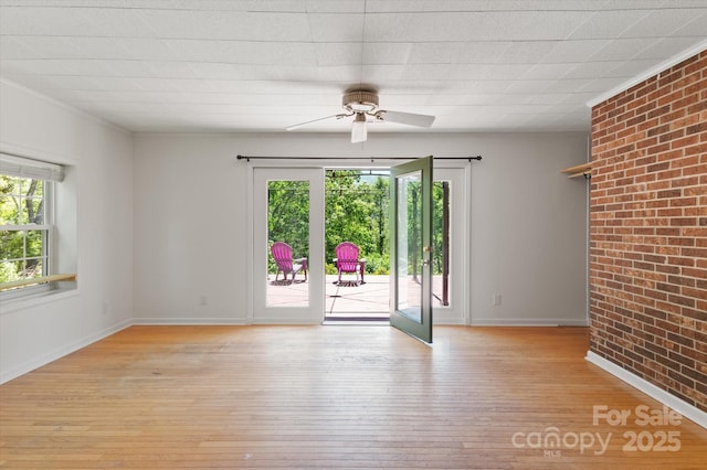 103 Hampshire Ln, Canton, NC 28716 - unfurnished room featuring light wood-type flooring, a ceiling fan, brick wall, and baseboards