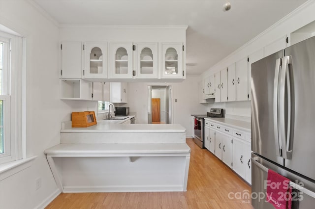 103 Hampshire Ln, Canton, NC 28716 - kitchen featuring stainless steel appliances, a sink, a peninsula, light wood finished floors, and white cabinetry
