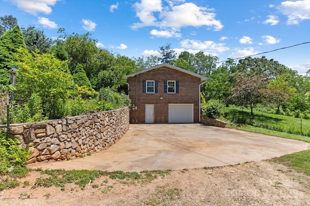 103 Hampshire Ln, Canton, NC 28716 - view of property exterior with driveway, brick siding, a garage, and view of wooded area