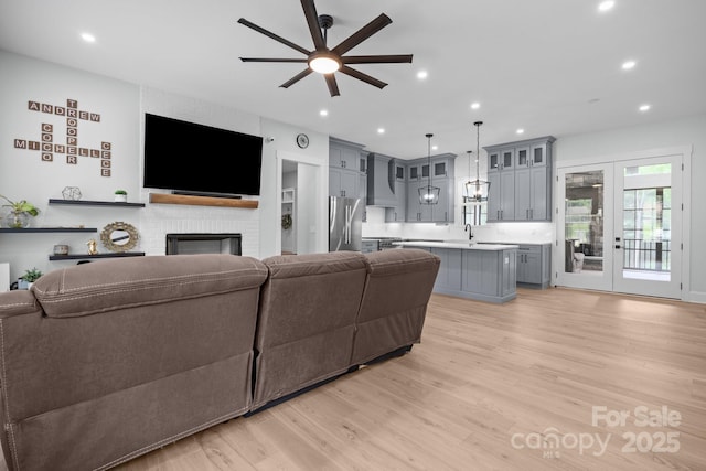 2577 Bonnybrook Cir, Rock Hill, SC 29732 - living room with ceiling fan, light wood-style flooring, recessed lighting, and a brick fireplace