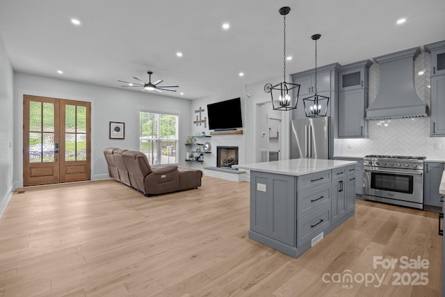 2577 Bonnybrook Cir, Rock Hill, SC 29732 - kitchen with high end appliances, gray cabinets, premium range hood, a brick fireplace, and light countertops