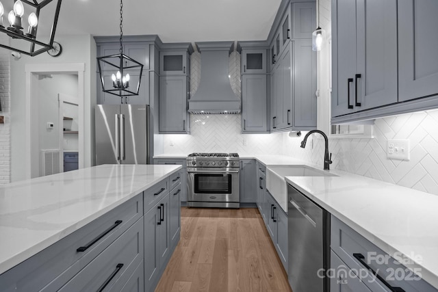 2577 Bonnybrook Cir, Rock Hill, SC 29732 - kitchen featuring high quality appliances, a chandelier, wall chimney range hood, gray cabinetry, and a sink