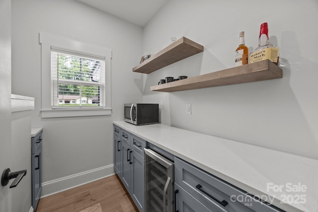 2577 Bonnybrook Cir, Rock Hill, SC 29732 - bar area with wine cooler, stainless steel microwave, light wood finished floors, and baseboards
