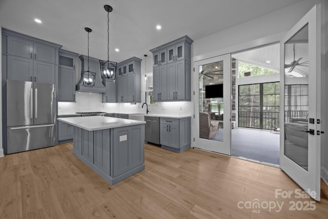 2577 Bonnybrook Cir, Rock Hill, SC 29732 - kitchen with appliances with stainless steel finishes, gray cabinetry, custom exhaust hood, light countertops, and light wood finished floors