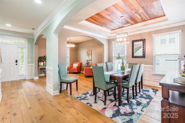 85017 Newloch Ct, Lancaster, SC 29720 - dining room with a tray ceiling, a chandelier, a decorative wall, light wood-type flooring, and arched walkways
