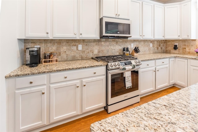 85017 Newloch Ct, Lancaster, SC 29720 - kitchen featuring appliances with stainless steel finishes, white cabinetry, tasteful backsplash, and light wood-style flooring
