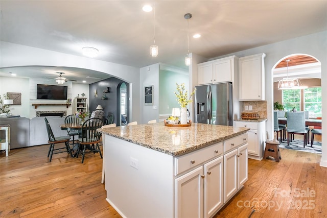 85017 Newloch Ct, Lancaster, SC 29720 - kitchen with stainless steel fridge with ice dispenser, arched walkways, a ceiling fan, white cabinetry, and light wood-style floors