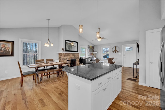 11 Ridge Brook Dr, Weaverville, NC 28787 - kitchen featuring a ceiling fan, a fireplace, light wood finished floors, white cabinetry, and high vaulted ceiling