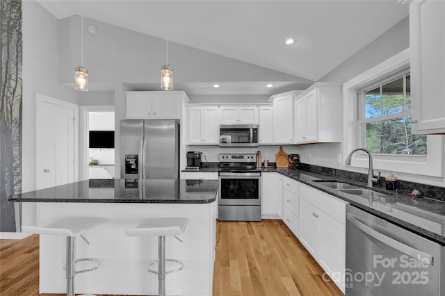 11 Ridge Brook Dr, Weaverville, NC 28787 - kitchen with stainless steel appliances, vaulted ceiling, a sink, white cabinetry, and light wood-style floors