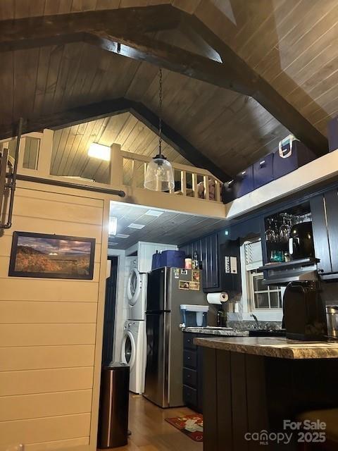 623 Overlook Dr, Spruce Pine, NC 28777 - kitchen featuring stacked washer and clothes dryer, freestanding refrigerator, wooden ceiling with exposed beams, under cabinet range hood, and high vaulted ceiling