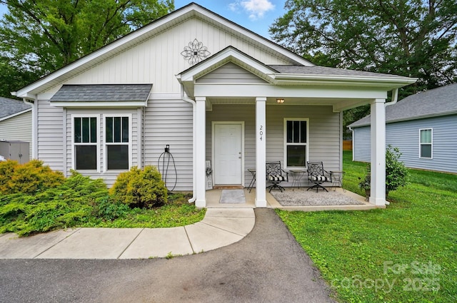 204 Craig St, Mount Holly, NC 28120 - view of front of property featuring a porch, a front yard, board and batten siding, and roof with shingles