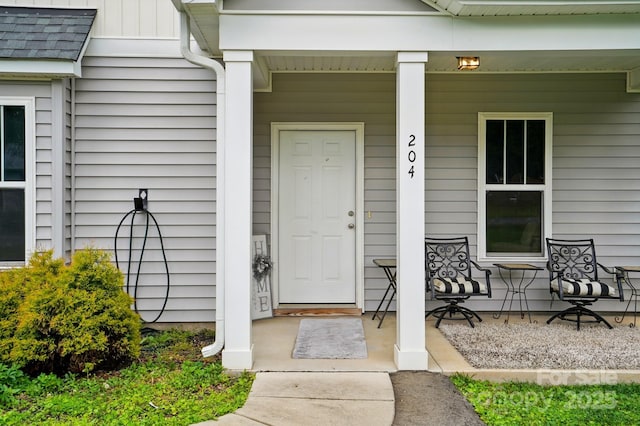 204 Craig St, Mount Holly, NC 28120 - view of exterior entry featuring a porch and roof with shingles