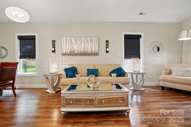 204 Craig St, Mount Holly, NC 28120 - living room featuring dark wood-style flooring, baseboards, and a chandelier