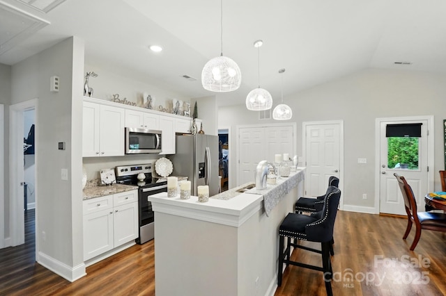 204 Craig St, Mount Holly, NC 28120 - kitchen with appliances with stainless steel finishes, dark wood-style flooring, an island with sink, white cabinets, and vaulted ceiling