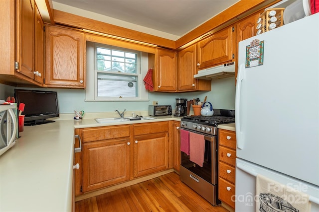 108 Connally St, Black Mountain, NC 28711 - kitchen featuring appliances with stainless steel finishes, under cabinet range hood, light countertops, light wood-type flooring, and brown cabinetry
