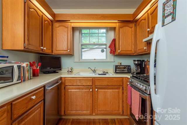 108 Connally St, Black Mountain, NC 28711 - kitchen featuring appliances with stainless steel finishes, light countertops, brown cabinets, under cabinet range hood, and wood finished floors