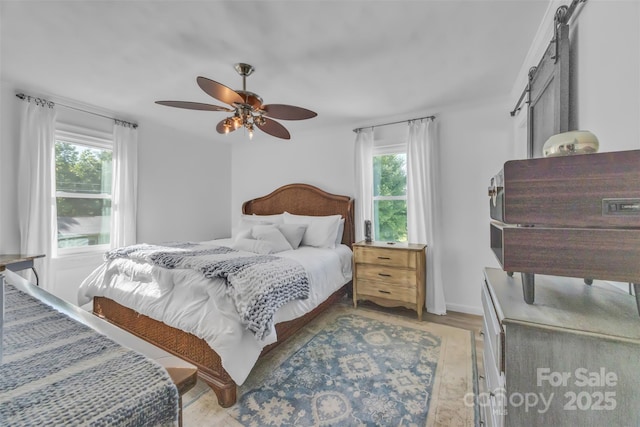 1 Plaza Dr, Granite Falls, NC 28630 - bedroom with multiple windows, a barn door, ceiling fan, and wood finished floors
