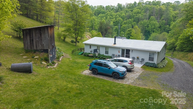 559 Mouth Of Silas Creek Rd, Lansing, NC 28643 - view of front of home with a wooded view, a front yard, and gravel driveway
