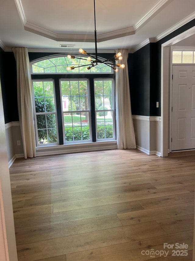 2567 Holly Oak Ln, Gastonia, NC 28056 - unfurnished dining area featuring a chandelier, a raised ceiling, hardwood / wood-style flooring, ornamental molding, and plenty of natural light