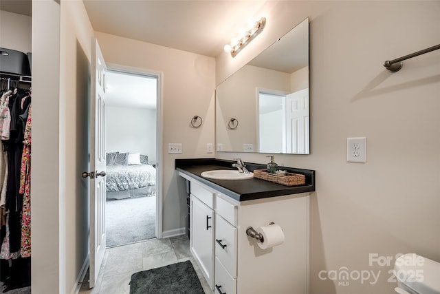 415 Kickapoo Ave, Gastonia, NC 28056 - bathroom with vanity, a spacious closet, ensuite bath, marble look tile flooring, and baseboards