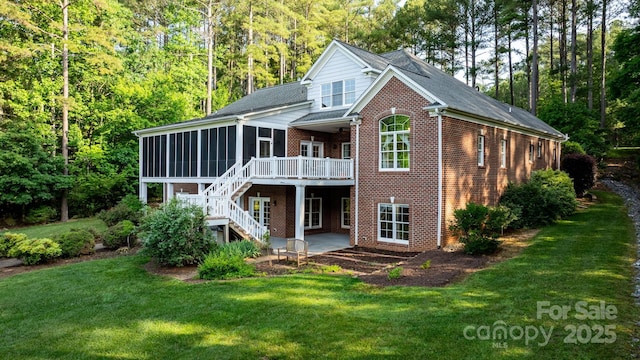 5487 Back Shore Dr, Granite Falls, NC 28630 - back of property with a sunroom, brick siding, a patio, and a lawn