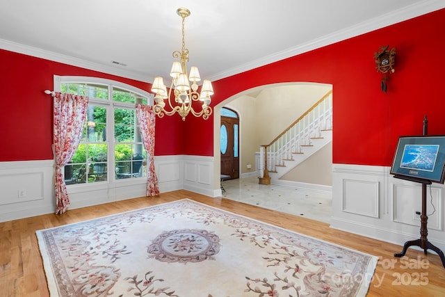 5487 Back Shore Dr, Granite Falls, NC 28630 - foyer featuring arched walkways, a chandelier, wainscoting, ornamental molding, and wood finished floors