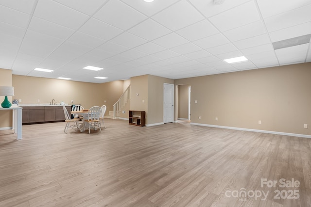 5487 Back Shore Dr, Granite Falls, NC 28630 - unfurnished dining area with a sink, light wood-type flooring, a paneled ceiling, stairs, and baseboards