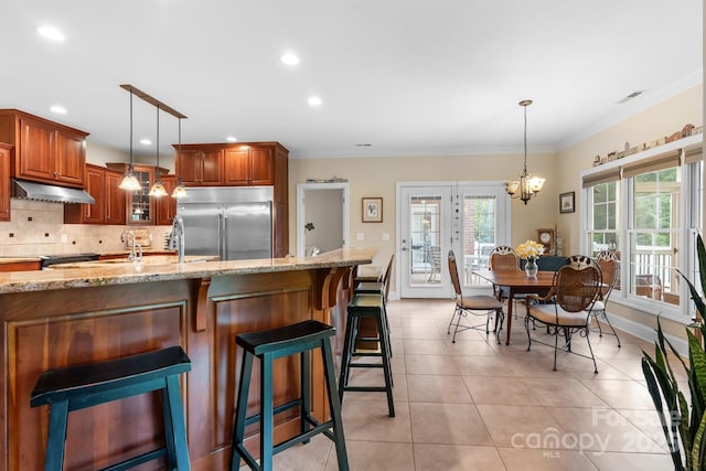 5487 Back Shore Dr, Granite Falls, NC 28630 - kitchen with stainless steel built in refrigerator, under cabinet range hood, light stone counters, light tile patterned floors, and backsplash