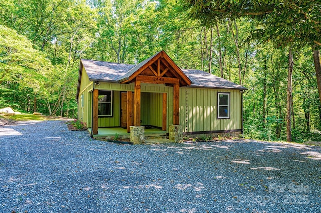 2448 Alfred Hartley Rd, Lenoir, NC 28645 - view of front facade with roof with shingles, a wooded view, and board and batten siding