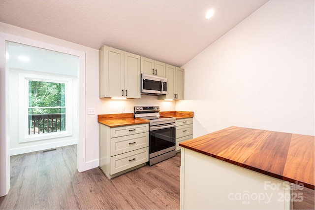 2448 Alfred Hartley Rd, Lenoir, NC 28645 - kitchen featuring butcher block counters, appliances with stainless steel finishes, vaulted ceiling, light wood finished floors, and baseboards