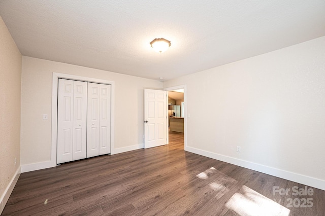 2448 Alfred Hartley Rd, Lenoir, NC 28645 - unfurnished bedroom with dark wood finished floors, baseboards, and a closet